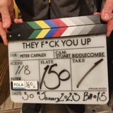 Close-up shot of a clapperboard from the set of new pilot show entitled They F*ck You Up
